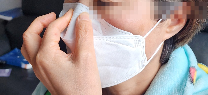 코 부분의 클립(코편)을 손가락으로 눌러 콧등에 밀착시키는 장면