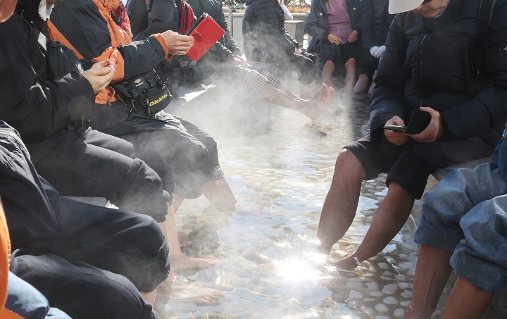 부산 지역 아침 최저기온이 영하로 떨어진 지난해 12월 3일 해운대해수욕장 온천족욕탕을 찾은 어르신들이 따뜻한 온천물에 발을 담근 채 추위를 녹이고 있다.2025.12.3.(사진=저작권자(c) 연합뉴스, 무단 전재-재배포 금지)