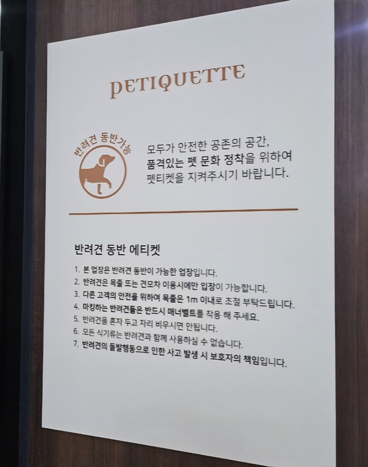 출입구에 반려견 동반 에티켓과 반려견 동반 가능 표시가 부착되어 있다.