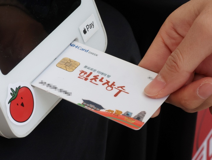 전북 장수군민에게 '농어촌 기본소득'이 처음 지급된 26일 장수군청 앞에서 진행된 상생소비 한마당에서 한 군민이 기본소득으로 물건을 구매하고 있다. 2026.2.26 (사진=저작권자(c) 연합뉴스, 무단 전재-재배포 금지)