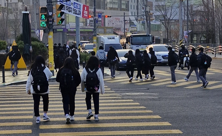 많은 학생들이 교복을 입고 등교하고 있다.