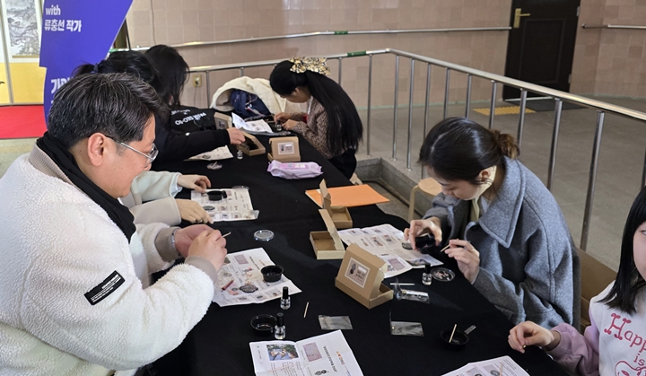 신청한 관람객들이 자개 키링을 만들고 있다.