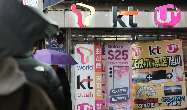 휴대전화를 개통할 때 신분증만 제시하던 것에서 패스 앱을 이용해 얼굴 사진을 찍어 본인임을 확인받는 절차가 시범 실시되는 23일 서울의 한 휴대폰 매장 앞을 시민들이 오가고 있다.2025.12.23.(사진=저작권자(c) 연합뉴스, 무단 전재-재배포 금지)