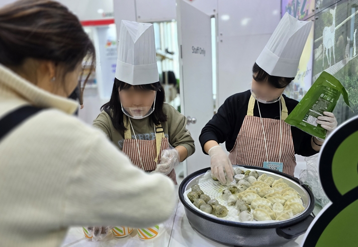 관람객이 강원도 태백의 명물, 곤드레 만두를 시식하고 있다.