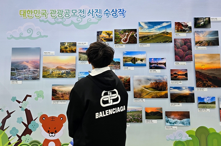 관광공모전 사진 수상작을 바라보는 관람객.