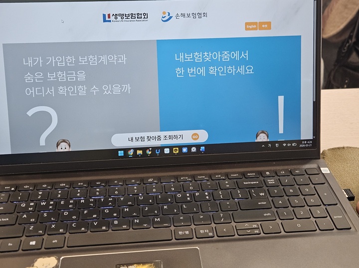 노트북을 켜고 '내 보험 찾아줌' 메인 화면에 접속해 조회를 시작하는 모습