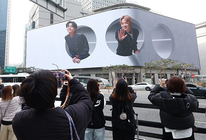 방탄소년단(BTS) 컴백 공연 다음 날인 22일 오전 서울 중구 신세계백화점 인근에서 방탄소년단의 팬클럽 ARMY가 송출되는 BTS의 모습을 사진 찍고 있다.(ⓒ뉴스1, 무단 전재-재배포 금지)