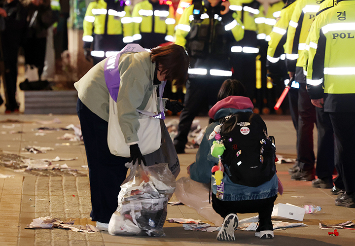 21일 오후 서울 종로구 광화문광장에서 열린 'BTS 컴백 라이브: 아리랑'이 끝난 후 한 아미 자원봉사단원이 쓰레기를 치우고 있다.(ⓒ뉴스1, 무단 전재-재배포 금지)