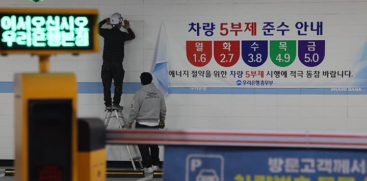 25일 서울 중구 우리은행 본점 주차장에서 관계자들이 '차량 5부제' 관련 안내문을 붙이고 있다. 중동 전쟁으로 에너지 수급 불안이 커진 가운데 금융지주들도 정부의 에너지 절감 정책에 동참하고 나섰다. 2026.3.25 (사진=저작권자(c) 연합뉴스, 무단 전재-재배포 금지)
