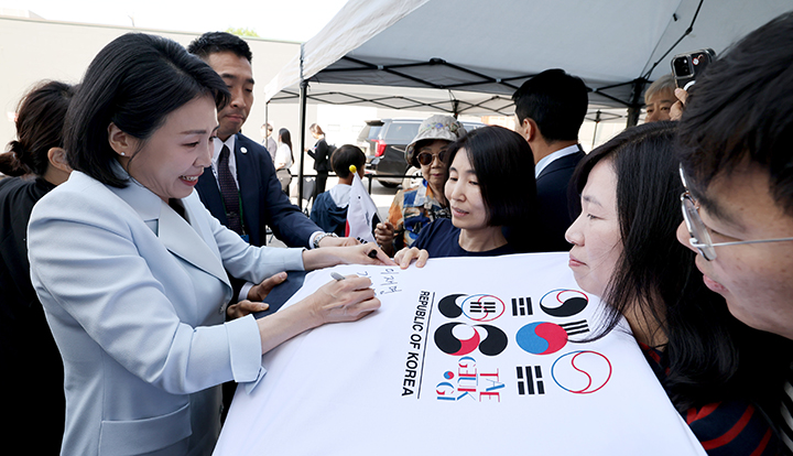 G7 정상회의에 참석하는 이재명 대통령과 함께 캐나다를 방문한 김혜경 여사가 17일(현지시간) 캘거리 한인회관에서 환영나온 주민들의 요청에 티셔츠에 서명하고 있다. 2025.6.18 (사진=저작권자(c) 연합뉴스, 무단 전재-재배포 금지)