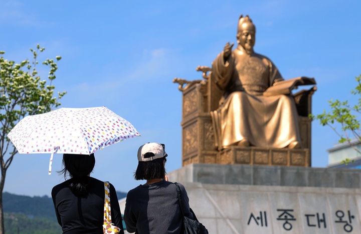 서울 낮 최고기온 28도까지 오르며 초여름 날씨를 보인 지난 13일 오후 서울 종로구 광화문광장에서 시민들이 양산을 쓴 채 세종대왕 동상 앞을 지나고 있다.(ⓒ뉴스1, 무단 전재-재배포 금지)