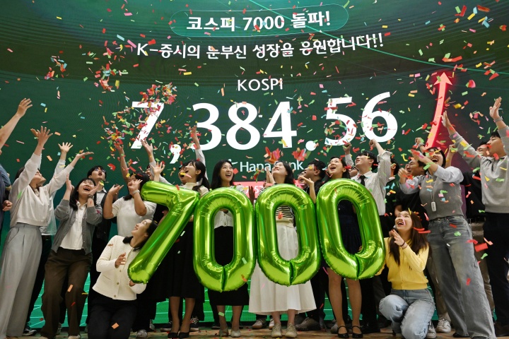 코스피가 종가 기준 사상 처음 7000선을 돌파한 6일 서울 중구 하나은행 딜링룸에서 직원들이 축하 세레머니를 하고 있다. 2026.5.6 (ⓒ뉴스1, 공동취재, 무단 전재-재배포 금지)