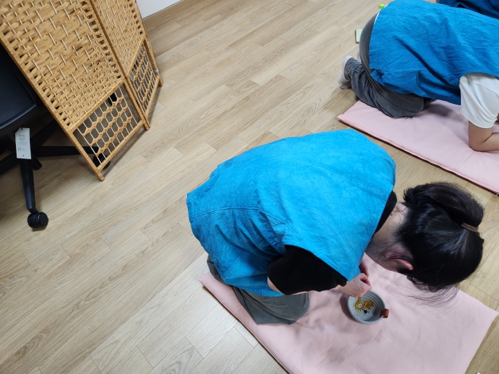 절 수행을 하며 염주를 한 알씩 꿰고 있는 참여자들 (본인 촬영)