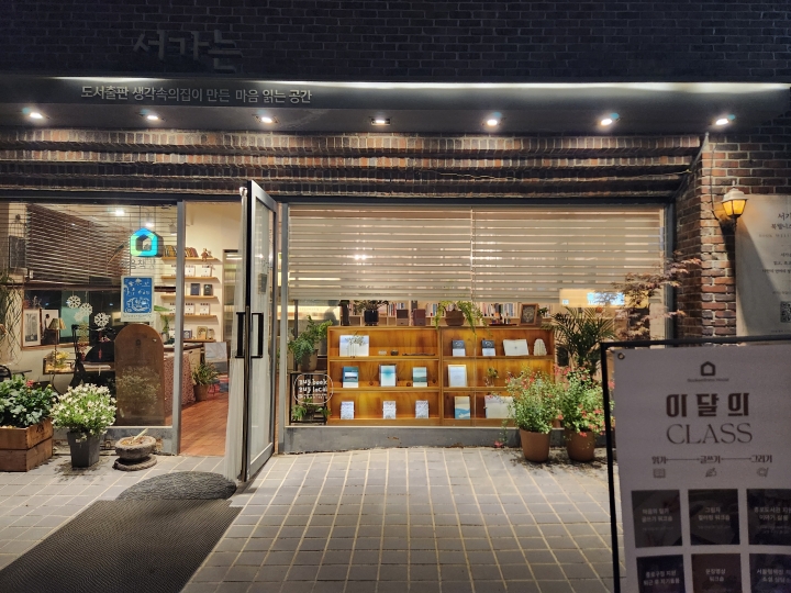 '문화요일&times;심야책방' 프로그램이 진행 중인 저녁 시간의 '마음책방 서가는' 외부 모습. 늦은 밤까지 불이 켜진 동네 책방이 골목을 밝히고 있다. (본인 촬영)