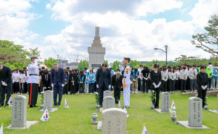 권오을 국가보훈부 장관이 5일 오전 제71회 현충일을 맞아 서울 동작구 국립서울현충원에서 열린 국화 한 송이 헌화행사에서 강호동 농협중앙회장 및 농협 임직원, 중앙대학교 학생들과 함께 제6묘역 각각 돌화병에 국화 한송이를 꽂은 후 묵념을 하고 있다.(ⓒ뉴스1, 국가보훈부 제공, 무단 전재-재배포 금지)