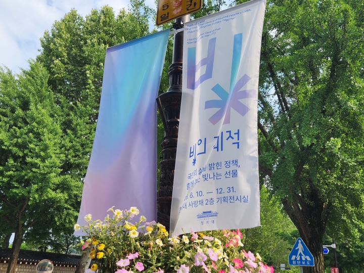청와대사랑채로 향하는 길목에 걸린 국민주권정부 1주년 기념 특별전 '빛의 궤적' 현수막 (본인 촬영)
