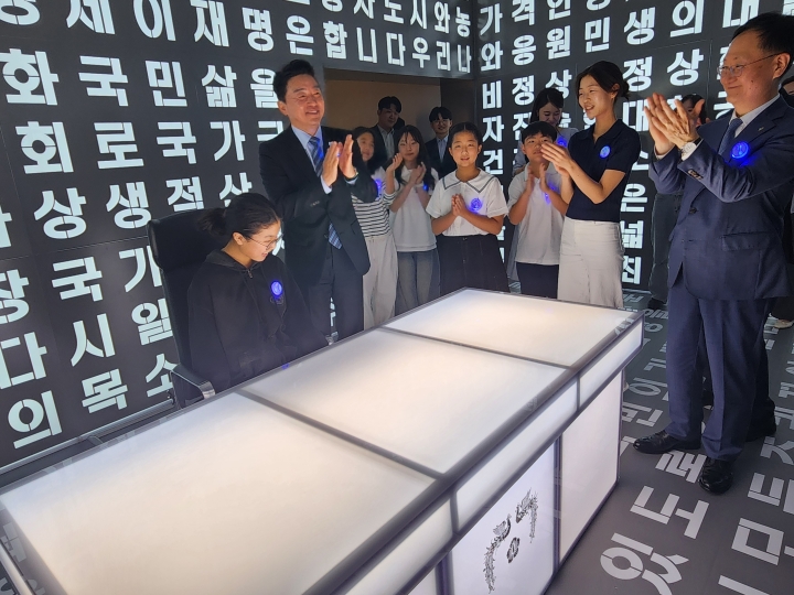 대통령 집무실을 재현한 공간에서 청운초등학교 학생이 의자에 앉아 체험하고, 강훈식 대통령비서실장과 참석자들이 박수를 보내고 있다. (본인 촬영)
