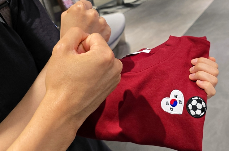 거리 응원에 입고 갈 옷에 와펜을 부착한 두 대학생이 파이팅을 외치고 있다. (본인 촬영)