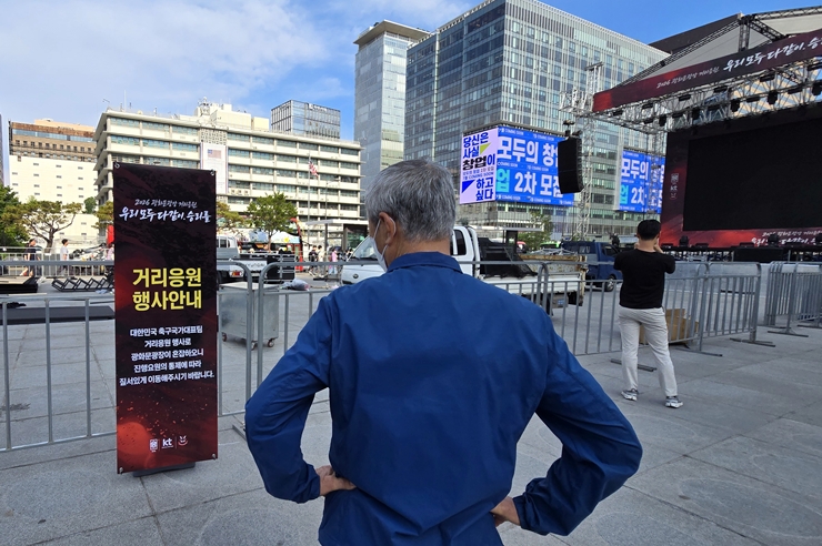 지나가던 시민이 거리 응원에 관한 안내문을 읽고 있다. (본인 촬영)