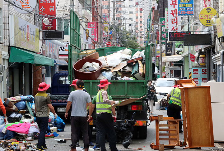 28일 오전 광주 남구 주월동 거리에서 구청 관계자들이 전날 국지성 호우로 침수피해를 당해 주민들이 길거리로 내놓은 물품을 수거하고 있다. 2018.8.28 (사진=저작권자(c) 연합뉴스, 무단 전재-재배포 금지)