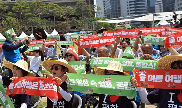 '올여름 여행은 농촌으로!' 피켓을 든 시민들과 관계자들이 올여름 농촌 관광 활성화를 외치며 활기차게 응원하고 있다(본인촬영).