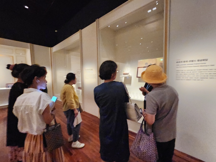 해설사의 설명을 들으며 관람객들이 전시품을 살펴보고 있다. 전시 해설은 유물과 기록의 의미를 이해하는 데 도움을 준다. (본인 촬영)