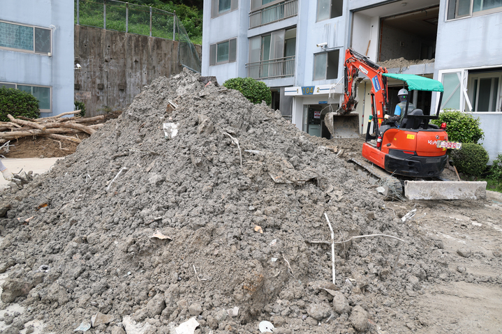 21일 오전 경남 거제시 옥포동의 한 아파트에서 굴착기를 동원해 집중호우로 밀려든 토사를 치우는 복구작업이 이뤄지고 있다. 이 아파트에서는 지난 17일 집중호우로 토사가 유출돼 사상자가 발생했다. 2026.8.21 (사진=저작권자(c) 연합뉴스, 무단 전재-재배포 금지)
