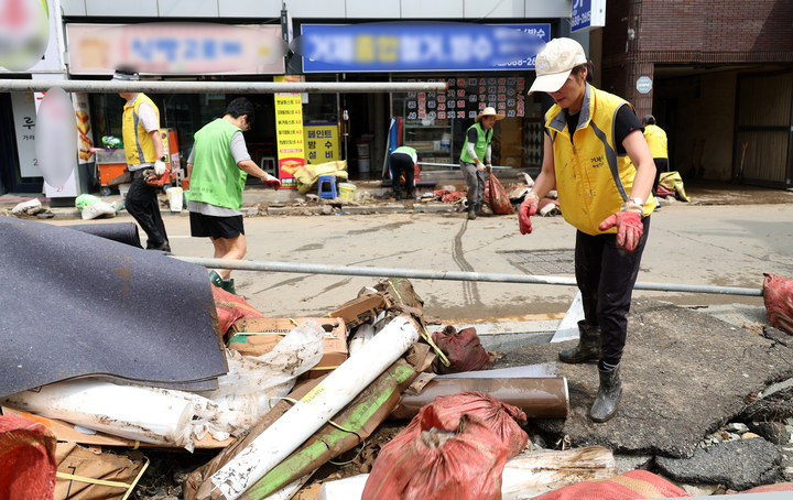 정부는 21일 집중호우로 큰 피해를 본 경남 거제시와 통영시 산양읍·봉평동을 특별재난지역으로 선포했다. 사진은 이날 거제시 옥포동에서 자원봉사자들이 침수 피해를 본 상가 주변의 토사와 폐기물을 치우며 복구 작업을 하는 모습. 2026.8.21 (사진=저작권자(c) 연합뉴스, 무단 전재-재배포 금지)