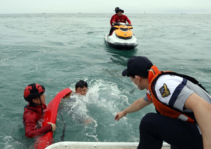 격적인 여름 피서철을 앞둔 13일 부산 해운대구 송정해수욕장 앞바다에서 부산해경 경찰관들이 피서객 구조 시범을 펼치고 있다. 2022.7.13 (사진=저작권자(c) 연합뉴스, 무단 전재-재배포 금지)