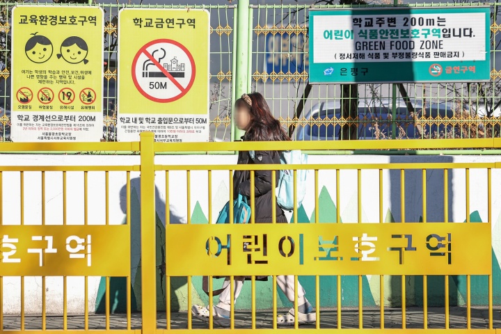 서울의 한 초등학교에 등교하는 어린이 위로 교육환경보호구역 및 어린이 식품안전보호구역 안내 표지판이 설치돼 있다. 2025.2.24. (ⓒ뉴스1, 무단 전재-재배포 금지)