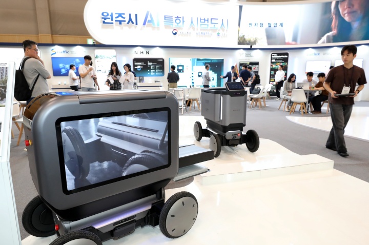 부산 해운대구 벡스코 제1전시장에서 열린 '2026 월드 스마트시티 엑스포'에서 참가자들이 원주시 AI 특화 시범도시 공동관을 찾아 배송·분리수거 서비스 로봇을 살펴보고 있다. 2026.9.9. (ⓒ뉴스1, 무단 전재-재배포 금지)