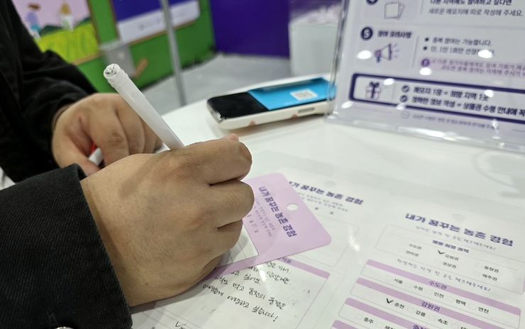 관람객이 희망하는 농촌 여행지와 체험 사연을 적고 있다.<본인 촬영>