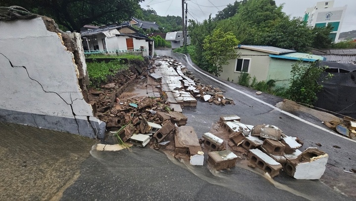 밤새 내린 폭우로 14일 오전 5시33분께 전남 영광군 영광읍의 한 주택 담벼락이 도로로 무너져 내려 통행이 통제되고 있다. 2023.7.14 (사진=영광군)