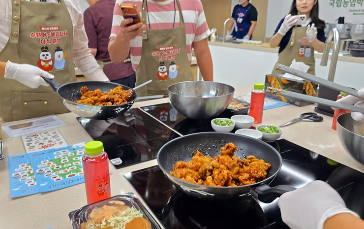 참가자들이 팬에서 치킨에 노릇하게 양념을 입히고 있다. (본인 촬영)