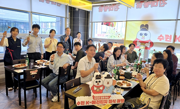 매장 안에서 다 같이 치킨 조각을 들고 자세를 취하는 참가자들 (본인 촬영)