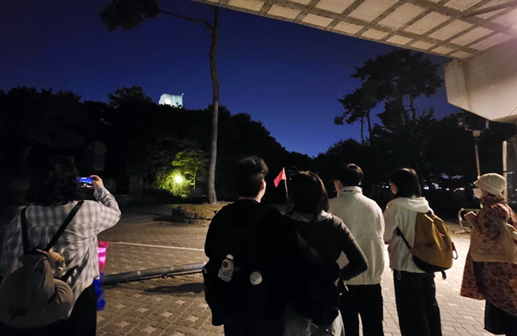 해설사의 안내를 받으며 언덕 위 절두산 순교성지 종탑을 바라보는 참가자들.(본인촬영)