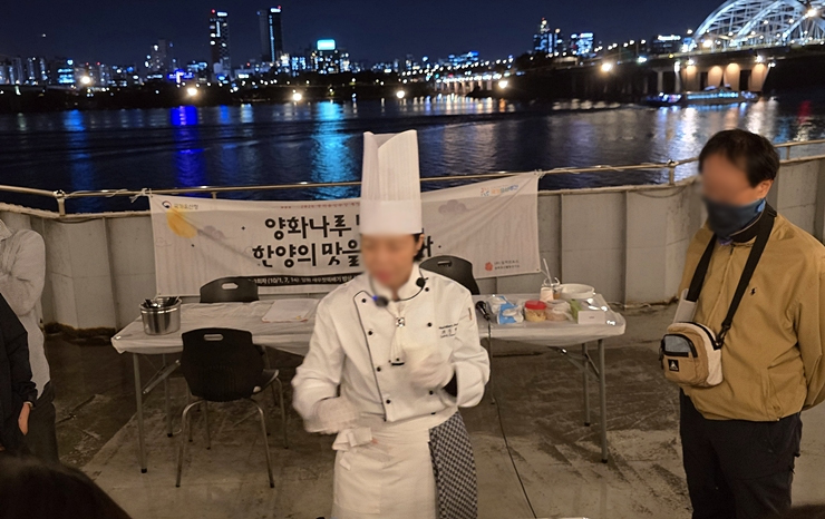 현수막 앞에서 요리 시연과 설명을 진행하는 조리사 (본인 촬영)