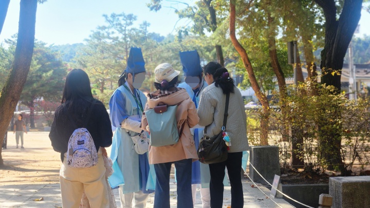 퀴즈를 풀던 사람들이 조선왕릉축전 서포터즈 '능이랑'에게서 힌트를 얻고 있다. (본인촬영)