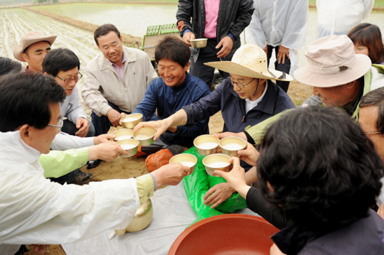 이명박 대통령이 26일 충북 충주시 주덕읍 화곡리에서 모내기를 마친 후 농부들과 새참으로 막걸리를 마시며 이야기를 나누고 있다.