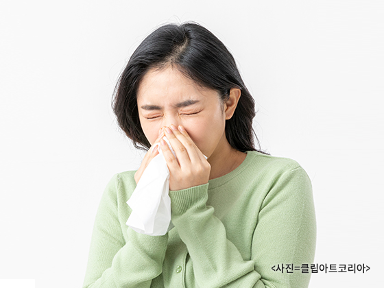 콧물을 닦고있는 여자.